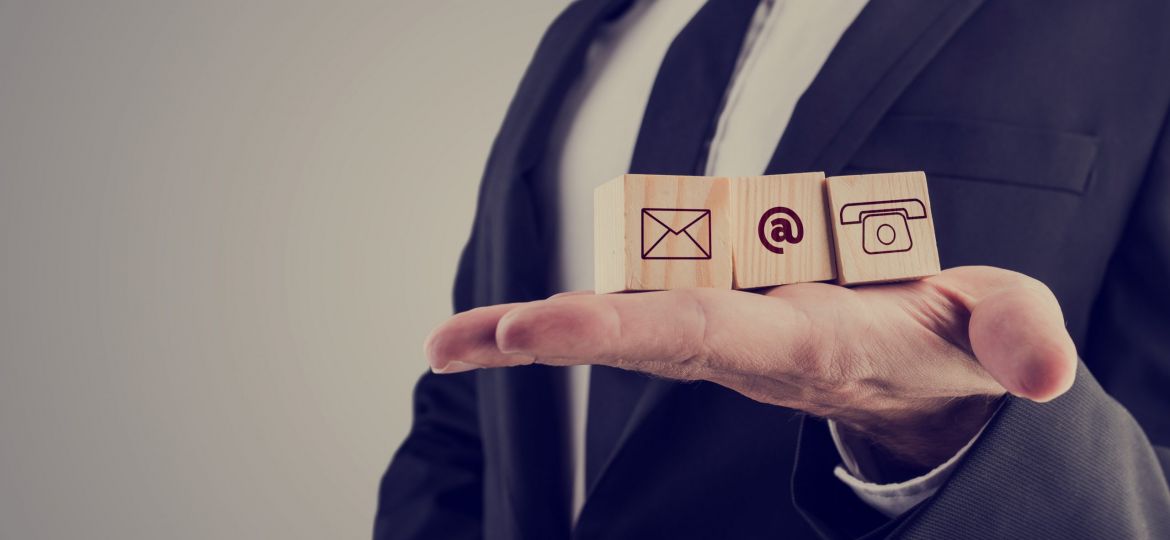 Businessman holding three wooden cubes with contact symbols